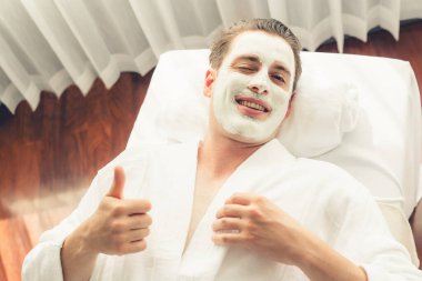 Kaplıca salonunun sakin atmosferi, insan müşterisi modern gün ışığında lüks yüz kremi masajıyla kendini yenileme zevkine kapılıyor. Yüz bakımı ve güzellik konsepti. Sessiz.