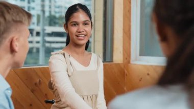 Genç öğrenci toplantıda veya grup tartışmasında diğer öğrencileri dinlerken gülümsüyor. Tecrübelerinden ve karışık ırktan arkadaşlarıyla paylaştığından bahseden sevimli bir genç. Yaratıcı eğitim. Öğretim