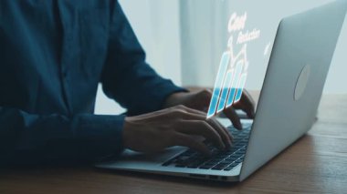 Etkileşimli teknoloji grafikleri dijital yenilik ve çevrimiçi güvenliği temsil eden veri analizi ve finansal simgeleri gösterirken, eller dizüstü bilgisayarda yazı yazmaktadır. Dörtgen.