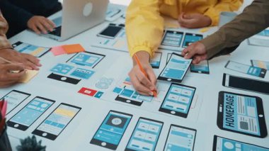 Akıllı telefon uygulama tasarımı ile uğraşan işbirlikçi bir ekibin yer aldığı canlı bir çalışma alanı. Prototipler ve notlar, yaratıcılığı ve yeniliği ön plana çıkaran bir tabloya yayılır. SACTR