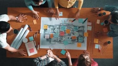 Zeki iş adamlarının el sıkışması ve kontrat yapmaları. Birlikte çalışan mimar mühendisinin hava görüşü ve planlar ve notlarla masada proje veya plan yapmak. Sempozyum.