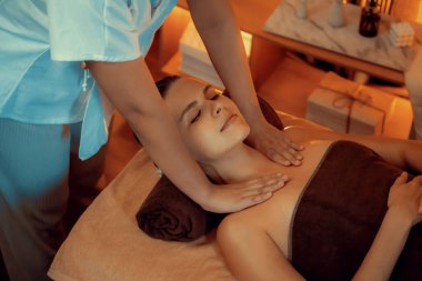 Beyaz kadın müşteri stres önleyici spa masajının keyfini çıkarıyor ve lüks otel ya da otelde sıcak mum ışığında güzellik teniyle eğleniyor. Sessiz.