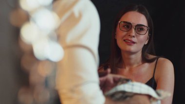 Güzel bir kadının portresi, lüks tezgahtaki temizlik ekipmanlarını temizlerken arka tarafta barmenle canlı bir konuşma yapıyor. Gece hayatındaki sosyetik etkileşim sahnelerini yakalıyorum. Vinosity.