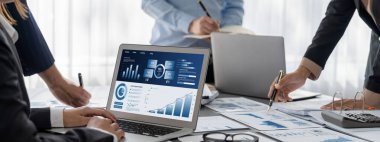 İş zekası ve veri analizi kavramı. Analizci ekibi laptop ekranında finansal veri analizi üzerinde çalışıyor. Etkili iş stratejik planlama için pazarlama göstergesi olarak. İçgörü