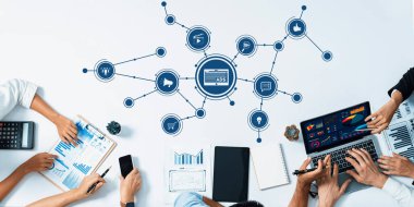 Reklam stratejileri, dijital cihazlar ve çeşitli raporların yer aldığı, modern pazarlama yaklaşımlarını yansıtan dinamik bir iş toplantısı. Dostluk