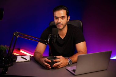 Yayıncı, fanclub dinleyicisiyle mikrofon kullanarak konuşuyor. Mor neon ışıklı modern stüdyoda yaratıcı olumlu düşünce konseptiyle canlı yayında finansal sorunları tartışıyor. Tahmin et..