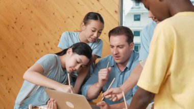 Akıllı robotlar sınıfta dizüstü bilgisayar ekranını işaret ederken, beyaz bir öğretmen yorum yapıyor ya da öğrencilere tavsiye veriyor. Öğretmen bilgisayar kullanırken çeşitli öğrencilerin ders verirken not alması. Öğretim