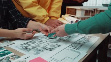 Modern bir çalışma alanında tasarım planları ve çizimler üzerinde işbirliği yapan, yaratıcılığı ve yenilikçi düşünceyi destekleyen canlı takım buluşması. SACTR