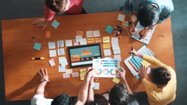 Web tasarımı için birlikte çalışan yetenekli iş adamlarının üst düzey görüşü. Bilgisayar veya dijital uygulama için web sitesi arayüzü hakkında beyin fırtınası yapan ve tartışan tasarımcıların hava görüntüsü. Sempozyum.