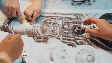 Bir mühendis, mekanik tasarım ve analizin karmaşık sürecini gösteren teknik çizimlerle çevrili ayrıntılı motor parçaları üzerinde çalışır. SACTR