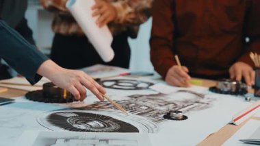 Bir grup profesyonel, yenilikçi çözümler geliştirmek için bir masanın teknik çizimleri ve planlarını tartışarak işbirlikçi bir mühendislik projesinde yer aldı. SACTR