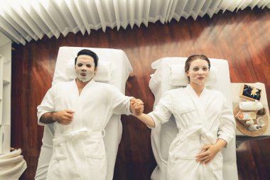 Kaplıca salonunun sakin, modern gündüz atmosferi, birkaç müşteri yüz maskesi takarak kendini yenilemeye çalışıyor. Yüz bakımı ve güzellik kozmetolojisi prosedürü. Sessiz.