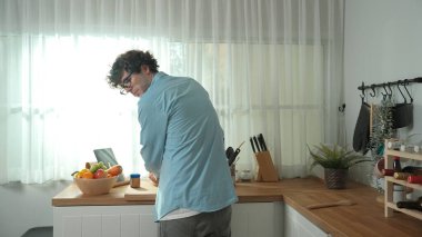 Mutlu baba yemek pişirirken müziğe geçiyor ve modern mutfakta öğle yemeği hazırlıyor. Aktif baba, sebze ve mutfak gereçleri ile çevrili sağlıklı yemek ya da salata yaparken şarkıyla dans ediyor. Pedagoji.