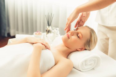 Kafkasyalı kadın stres önleyici kafa masajından ve lüks tatil beldesi ya da otel spa salonundaki modern ışık ortamında yüz güzelliği eğlencelerini şımartmaktan hoşlanıyor. Sessiz.