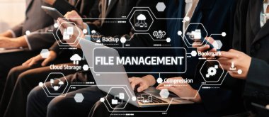 Bu görüntü, modern işyerlerinde üretkenliğin ve organizasyonun geliştirilmesinde teknolojinin rolünü vurgulayarak, etkin dosya yönetimi yapan iş profesyonellerini yakalar. Dostluk