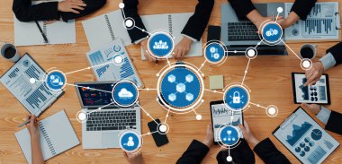 İş dünyasından profesyoneller, çeşitli sunum ve raporlar arasında veri analizi ve stratejik planlama için dijital araçlardan yararlanarak modern bir çalışma alanında işbirliği yapmaktadırlar. Dostluk