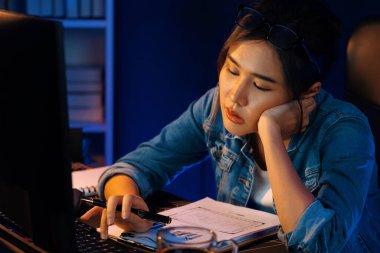 Bitkin düşmüş, genç, güzel Asyalı yaratıcı hisler, bilgisayardan e-posta beklemek için bekliyor. Projenin yaratıcısı sosyal medyanın veri tablosunu gece vakti neon ofiste karşılaştırıyoruz. Taktik.