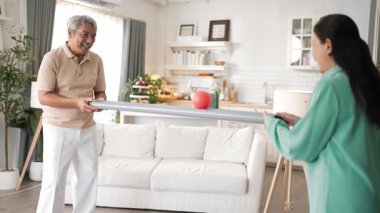 Yaşlı bir adam evde partneriyle top yuvarlama oyunu oynuyor, zihinsel ve fiziksel sağIık için el-göz koordinasyonu, odaklanma ve motor becerileri pratiği yapıyor. Sağlık hizmetleri konseptini engelliyor. Myrmidon.