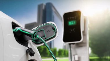 Yeşil Şehir Parkı 'ndaki ekolojik temiz enerji şarj istasyonundan gelen fütürist akıllı EV şarj aletinin şarj ettiği elektrikli araba. Alternatif enerji kullanan gelecekçi elektrikli araba. İnceleyin