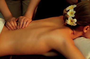 Beyaz kadın müşteri stres önleyici spa masajının keyfini çıkarıyor ve lüks otel ya da otelde sıcak mum ışığında güzellik teniyle eğleniyor. Sessiz.