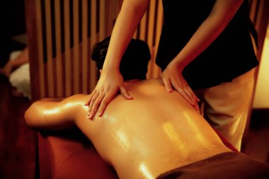 Beyaz erkek müşteri stres önleyici spa masajının keyfini çıkarıyor ve lüks otel ya da oteldeki ortam kaplıcalarında sıcak mum ışığında güzellik teniyle eğleniyor. Sessiz.