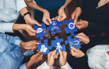 Çeşitli el grupları, bir şirket ortamında işbirliği, takım çalışması ve CRM kavramlarını, gösteri stratejisini ve yenilikleri sembolize eden bulmaca parçalarını birleştiriyor. Dostluk