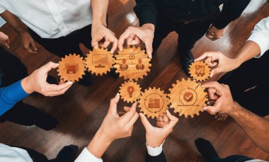 Çeşitli ellerin ahşap dişlileri tutması, şirket ortamlarında yenilik ve büyümeye yönelik iş stratejilerinde işbirliği ve takım çalışmasını sembolize eden hava görüşü. Dostluk