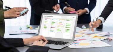 Analizci ekibi yaratıcı ve analitik beyin fırtınası fikri için bilgisayar ekranında BI veri paneli olan yapışkan bir not kullanıyor. Pazarlama stratejisi için finansal veri görselleştirme teknolojisini analiz et. Dahi.