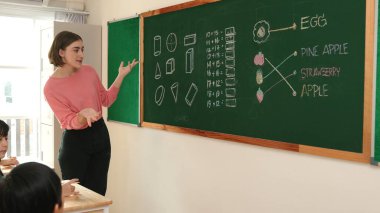 Zeki öğretmen sınıfta fikri açıklarken sevimli öğrenci ödevlerini kontrol ediyor. Not defterine bakıp matematik teorisinden çocuğa bahsederken sınıfta dolaşan çekici bir eğitmen. Pedagoji.