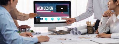 İç mimar tasarımcı grubu, daha kesin tasarım için planlar ve dizüstü bilgisayar ekran mimari yazılımı üzerinde birlikte tartışıyorlar. Modern ev tasarımı ve yenileme. İçgörü