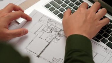 Mimari ya da mühendis, modern ofiste doğruluk için mimari belgeye veriler yazıp, dizüstü bilgisayarda ayrıntılı tasarım planı olan bir yapı tasarlıyor. - Yakın çekim. Tanımlama.