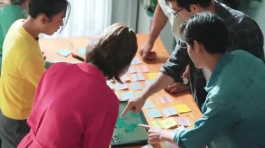 Ux Ui tasarımı kullanılarak dijital program ve yazıları tartışan ve gösteren geliştirici ekibin hava görüntüsü. İş dünyasına tepeden bakan insanlar telefon ve bilgisayar için kablo prototipi geliştiriyorlar. Sempozyum.