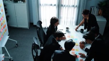 İş adamlarının toplantı odasında pazarlama stratejisi planlarken yapışkan notlar kullanarak beyin fırtınası yapma fikrine en iyi bakış açısı. Çeşitli takımlar mali planı tartışıyor. Takım çalışması konsepti. Müdürlük.