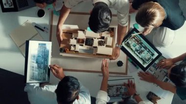 Yöneticinin ev modelini göstermesi ve bina tasarımını açıklaması. Tablet ev planı sergilenirken iç yapı hakkında beyin fırtınası yapan mimar mühendisinin hava görüntüsü. Hizalama.