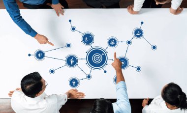 Çeşitli iş adamları, etkin planlamayı yürütmek için dijital verileri ve masadaki simgeleri analiz ederek beyin fırtınası yaptılar. Dostluk