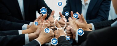 Profesyonel bir ortamda takım çalışmasının ve işbirliğinin dinamik bir temsili, yenilik ve stratejiyi sembolize eden teknoloji simgeleriyle el ele vermek. Dostluk