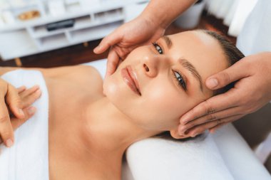 Kafkasyalı kadın stres önleyici kafa masajından ve lüks tatil beldesi ya da otel spa salonundaki modern ışık ortamında yüz güzelliği eğlencelerini şımartmaktan hoşlanıyor. Sessiz.