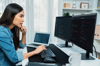 İnternet sitesi uygulamasının kodlama verileriyle birlikte online bilgi yazarak kot gömlek giyen genç Asyalı geliştirici. Güvenlik analizi ile çevrili iki ekran. Taktik.