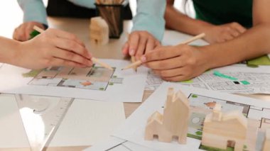 Mimari döküman, ölçüm araçları ve ahşap blokların modern ofiste etrafa saçıldığı masa üzerine planlar yapma konusunda akıllı mimar ve güvenlik mühendisi tartışması. - Yakın çekim. Tanımlama.