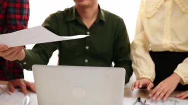 Akıllı mimar ve güvenlik mühendisi, mimari belge, ölçüm araçları ve ahşap blokların modern ofiste etrafa saçıldığı masa planlarını tartışıyor. - Yakın çekim. Tanımlama.