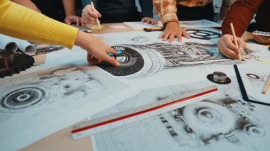 Karmaşık teknik çizimler ve planlar üzerinde işbirliği yapan mühendislerin dinamik bir sahnesi, üretken bir çalışma alanında yaratıcılık ve yenilik sergiliyor. SACTR