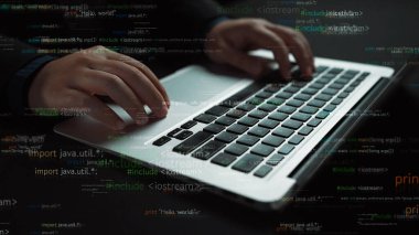 Dizüstü bilgisayarın klavyesinde canlı programlama kod parçacıklarıyla çevriliyken, yazılım geliştirme ve teknolojinin dinamik dünyasını sembolize eden elleri yakın çekim. Xenic