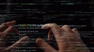 Yakın plan görüntü, kaynak kodların dinamik bir görüntüsüyle çevriliyken bir klavyede yazı yazan elleri yakalar ve programlamanın ve dijital yaratımın özünü gözler önüne serer. Xenic