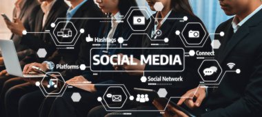 Mobil cihazlarla uğraşan bir grup birey, çağdaş bir iş ortamında sosyal medyanın ve bağlanabilirliğin etkilerini gösteriyor. Dostluk