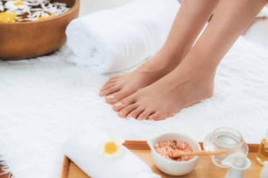 Panorama üstteki kadın lüks spa salonunda mutlu bir ayak masajı yaparken, masör de hafif gündüz atmosfer tesisinde veya otel ayak spasında refleksoloji terapisi uyguluyor. Sessiz.