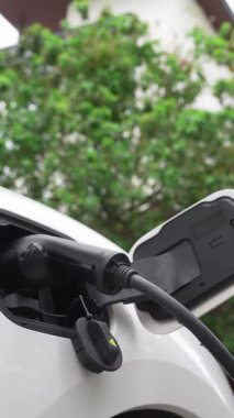 Elektrikli araba parkı ve şarj istasyonunun yanında şarj edilen enerji konseptinin sürdürülebilirliği. Çevresel koruma için yenilenebilir enerji tarafından kullanılan elektrikli araç.
