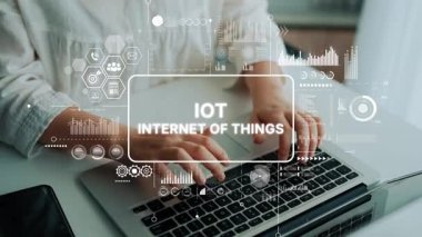 Modern bir çalışma ortamında fütüristik IoT grafikleri ve veri analizleriyle dizüstü bilgisayarda yazan birinin yakın çekimi. Asemptotik akıllı veri analitiği.