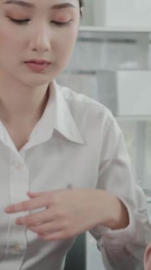 Ofis masasında çalışan iki hevesli genç iş kadını, veri tablosu raporlarıyla birlikte. Genç meslektaşlar istatistik veri kağıdı planları ve stratejisini tartışıyor ve analiz ediyorlar.