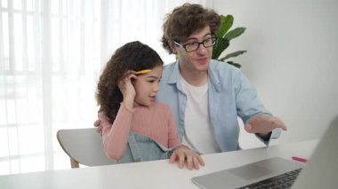 Baba, Amerikalı kız ekrana bakarken yapay zeka üretmeyi açıkla. Çekici beyaz bir baba, kızına kulaklıklı masada kod mühendisliği öğretiyor. Pedagoji.