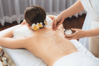 Lüks spa salonlarında sıcak mum ışığında cilt bakımı yaptıran kadın müşteri. Sağlık Spa vücut fırçasında tuz temizleme güzellik tedavisi. Sessiz.